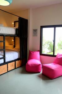 a bedroom with two bunk beds with pink pillows at Maya Papaya in Antigua Guatemala