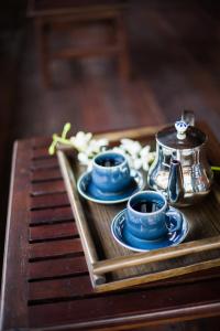 un vassoio con 2 tazze blu e un bollitore per il tè di Night Bazaar Inn a Chiang Mai
