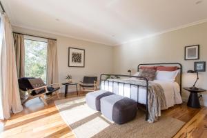 a bedroom with a bed and a chair and a window at Haven Red Hill in Red Hill