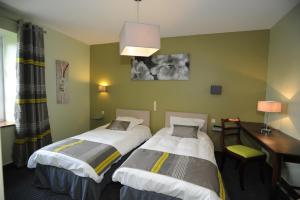 a hotel room with two beds and a desk at Domaine du Griffier in Granzay