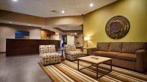 a waiting room with a couch and two chairs at Best Western Plus Night Watchman Inn & Suites in Greensburg