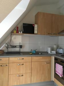 eine Küche mit Holzschränken und einer Spüle in der Unterkunft Formella in Eisenach
