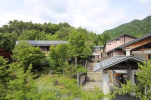 a view of a house with trees and buildings at Hotel Fuki no Mori in Nagiso