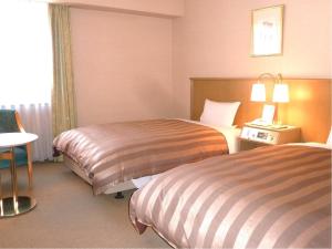 a hotel room with two beds and a window at Ark Hotel Royal Fukuoka Tenjin -ROUTE INN HOTELS- in Fukuoka