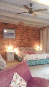 a bedroom with a bed and a brick wall at pamelas retreat in Bridgetown