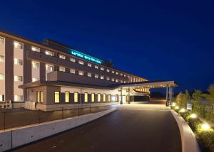 a building with a parking lot in front of it at Hotel Route Inn Osaka Izumi -Kishiwada Izumi Inter- in Izumi