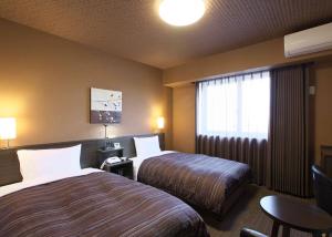 Krevet ili kreveti u jedinici u okviru objekta Hotel Route Inn Osaka Izumi -Kishiwada Izumi Inter-