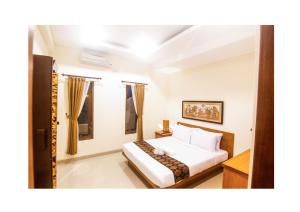 a bedroom with a bed in a room at Oes House in Ubud