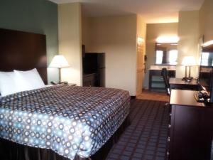 a hotel room with a bed and a desk at Pearsall Inn and Suites in Pearsall
