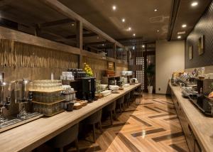 a restaurant with a long counter with food at ホテルルートインGrand北見駅前 in Kitami