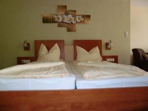 two beds with white pillows sitting next to each other at Pension Haus Waldfrieden, MeineCardPlus inklusive in Willingen