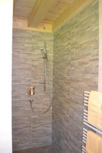 a bathroom with a shower with a stone wall at Ferienwohnung Hinterwinkl in Achenkirch