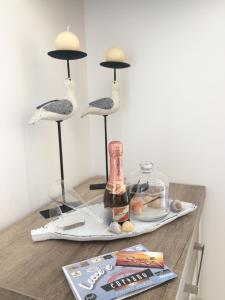 a table with three birds and a bottle of wine at Dimore di Mare in San Pietro Vernotico