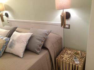 a bed with pillows and a side table with a lamp at Dimore di Mare in San Pietro Vernotico