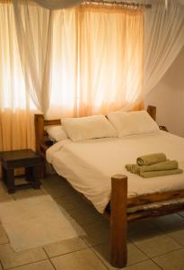 Schlafzimmer mit einem großen Bett und einem Fenster in der Unterkunft Vila la Mar Vilanculo in Vilankulo