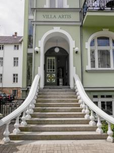 eine Treppe, die zu einem Gebäude mit einer Tür führt in der Unterkunft Apartamenty Villa Artis in Świnoujście