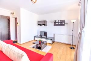 ブラショヴにあるEurope Residence Central Apartmentのリビングルーム(赤いソファ、テーブル付)