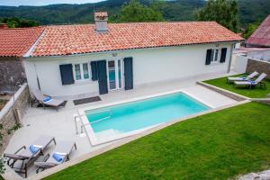 een luchtzicht op een huis met een zwembad bij Villa Orljak in Lanišće