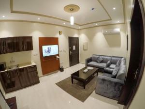 a living room with a couch and a table at Eskan Alreem Aparthotel in Jeddah +8 photos