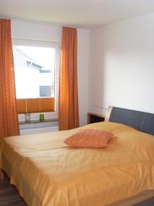 ブラウンラーゲにあるFerienwohnungen Lübbersのベッドルーム1室(黄色いベッド1台、窓付)