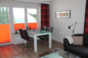 a living room with a glass table and chairs at Ferienwohnungen Lübbers in Braunlage