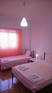 アテネにあるBozena Apartmentのベッド2台、窓(光付)が備わる客室です。