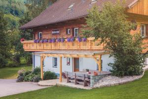 ein Holzhaus mit einer Terrasse und einer Bank in der Unterkunft Raderhof in Feld am See
