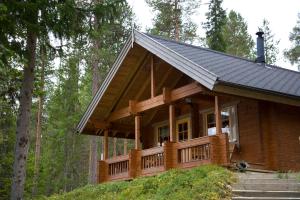 een blokhut in het bos met een veranda bij Ukonloma Härkälampi in Rovaniemi