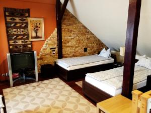 a small room with two beds and a tv at Pensjonat Pod Orzechami in Magdalenka +17 photos