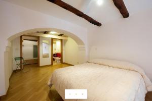 ナポリにあるLovely Holiday Apartmentのベッドルーム1室(白いベッド1台、アーチ付)