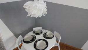 tavolo da pranzo bianco con sedie e lampadario pendente di Italianway-Piacenza a Milano