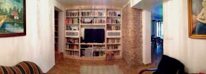 una sala de estar con un estante de libros con TV en Villa Podlachia en Wierzbice Górne