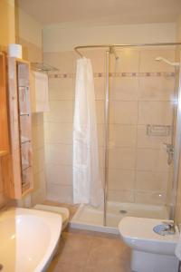 een badkamer met een douche, een toilet en een wastafel bij Médano Los Patios windsurfing area in El Médano