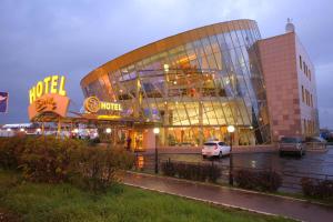 a large building with a car parked in front of it at Silky Way in Oktyabrskiy