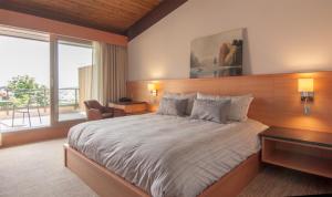 a bedroom with a large bed and a large window at Harbour House Hotel in Ganges