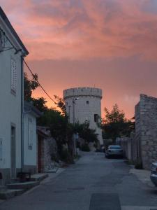 a castle with a car parked on a street at Apartman i Sobe Čule Cres in Cres
