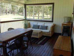 a screened in porch with a couch and a table at Loughmore House in Eukey