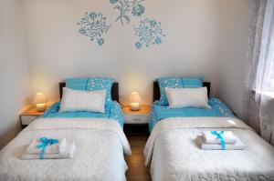 a bedroom with two beds with blue bows on them at Angel Apartment in Krynica Zdrój