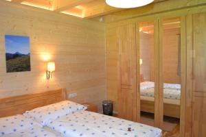 two beds in a room with wooden walls at Ferienwohnung Hinterwinkl in Achenkirch