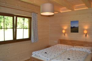 una camera da letto con un letto e due finestre di Ferienwohnung Hinterwinkl ad Achenkirch