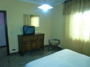 a bedroom with a bed and a television on a dresser at Affittacamere di Fabio Principale in Talsano