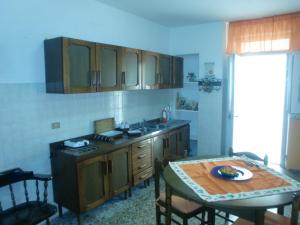 a kitchen with a table and a small kitchen with a table and a tablektop at Affittacamere di Fabio Principale in Talsano