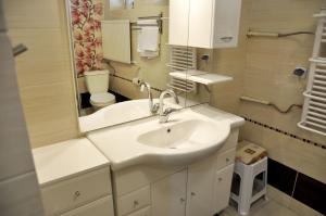 a bathroom with a sink and a toilet and a mirror at Angel Apartment in Krynica Zdrój