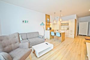 a living room with a couch and a table at Bursztynowa Apartments by Grand Apartments in Gdańsk