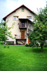 a house with a green lawn in front of it at Angel Apartment in Krynica Zdrój