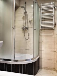 a shower with a glass door in a bathroom at Apartament Maryla in Giżycko