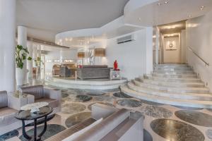 a lobby with a staircase with a couch and a table at Hotel Mariver in Lido di Jesolo