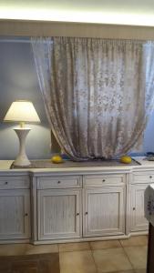 a white dresser with a lamp and a curtain at Villa Corali in Karfas