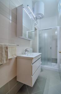 uma casa de banho com um lavatório e um chuveiro em Apartment Zora & Natale em Pula
