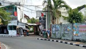 un hombre está de pie al lado de una calle en Room Sweet Room, Seminyak, en Seminyak